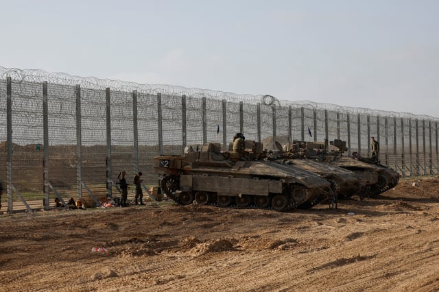 Soldiers sit on top of APC's, at the Israel-Gaza border, in Israel, March 18, 2025. REUTERS/Amir Cohen/File Photo