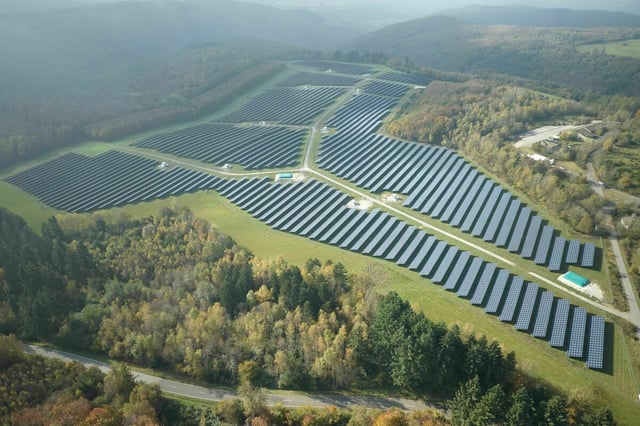 Drohnenaufnahme :Solaranlagen in einer Landschaft mit Wald
