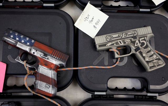 A U.S. flag-themed handgun and a Donald Trump-themed gun are displayed for sale at the Des Moines Fairgrounds Gun Show at the Iowa State Fairgrounds in Des Moines, Iowa, U.S. March 11, 2023. REUTERS/Jonathan Ernst/File Photo
