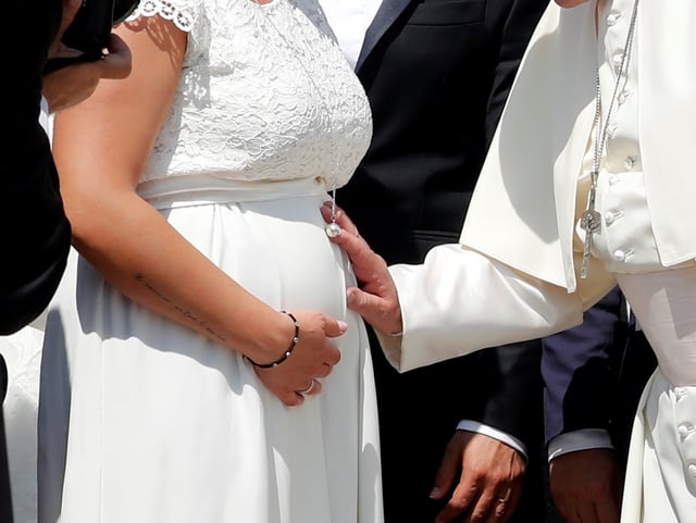 Pope Francis blesses a pregnant woman touching her belly during the weekly general audience at the Vatican, June 5, 2019. REUTERS/Remo Casilli