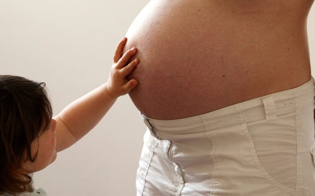 A child touches her pregnant mother's stomach at the last stages of her pregnancy in Bordeaux April 28, 2010. REUTERS/Regis Duvignau/File Photo