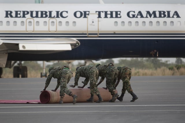 Soldiers roll back the red carpet near a parked Gambian Presidential aircraft on the tarmac of Banjul's airport Friday Jan. 20, 2016. 