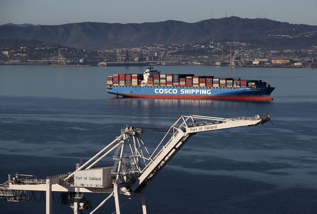 FILE: A container ship sits idle in San Francisco Bay outside the Port of Oakland on March 26, 2021.