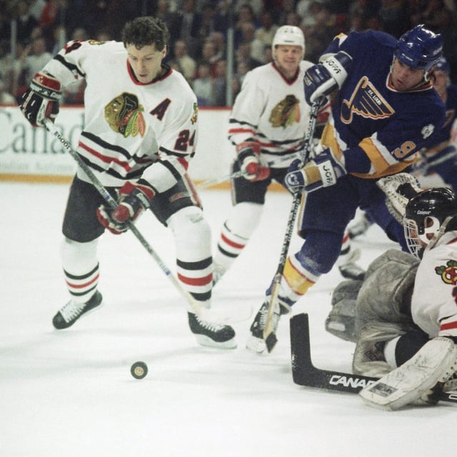 FILE--St. Louis Blues Peter Zezel (9) is stopped by Chicago Blackhawks goalie Greg Millen as Blackhawks' Doug Wilson (24) sweeps the puck away during action in Chicago, Friday, April 20, 1990. THE CANADIAN PRESS/AP-Fred Jewell