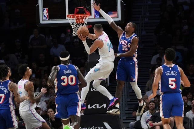 Miami Heat guard Tyler Herro (14) shoots over Philadelphia 76ers guard Lonnie Walker IV (16) during the first half of an NBA basketball game, Monday, April 7, 2025, in Miami. (AP Photo/Lynne Sladky)