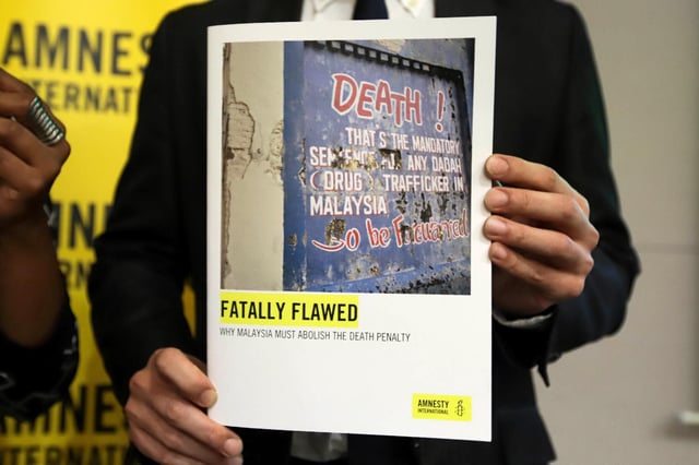Un membre d’Amnesty International montre un rapport sur la peine de mort en Malaisie, le 10 octobre 2019 à Petaling Jaya