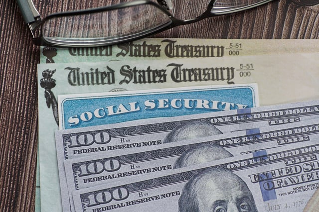 Stock image shows a Social Security card on cash and treasury department checks.