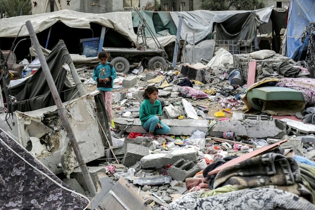 A young girl sat in the midst of a sea of rubble and metal rods after an Israeli strike in Deir el-Balah
