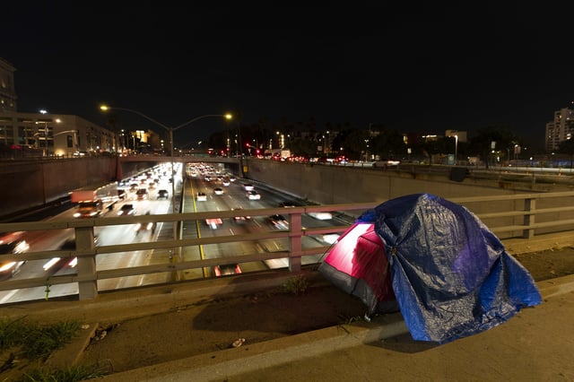 FILE - A tarp covers a portion of a homeless person's tent on a bridge overlooking the 101 Freeway in Los Angeles, Thursday, Feb. 2, 2023. (AP Photo/Jae C. Hong, File)