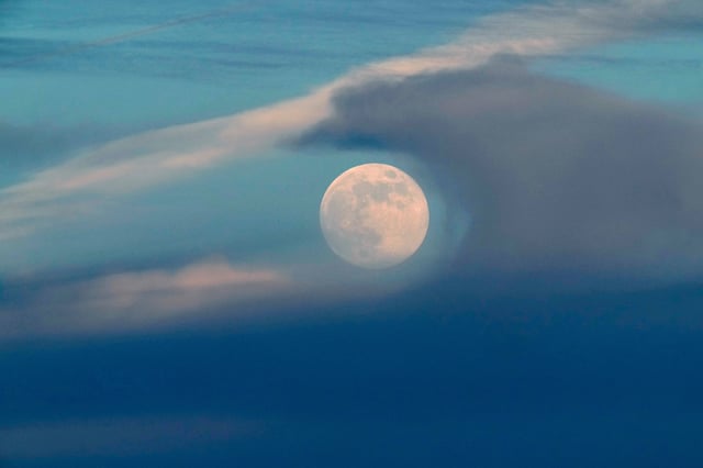 FILE - A full moon rises above the clouds at sunset in Lisbon, Saturday, Dec. 14, 2024. (AP Photo/Armando Franca, File)