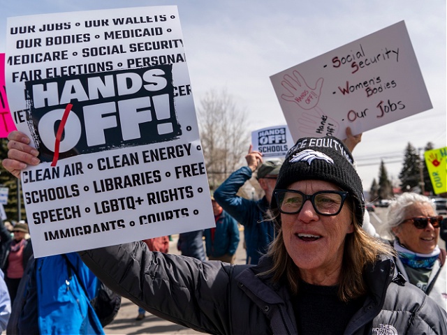 GUNNISON, CO - April 5 : A woman holds up a poster during a Hands Off protest in Gunnison, Colorado. April 5, 2025. Protesters gathered to voice their concerns over President Donald Trump's actions since taking office. (Photo by Don Emmert/VIEWpress)