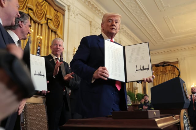 President Donald Trump holds an executive orders during a ceremony in the East Room of the White House 8, 2025, in Washington D.C.