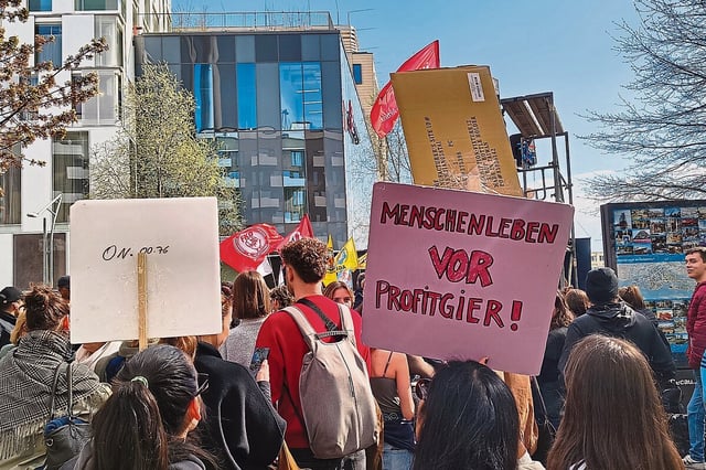Eine Demonstration in der Hamburger Hafwencity, im Vordergrunfd ein Schild: "Menschenleben vor Profitgier!"