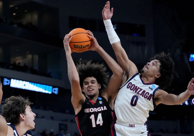 Mar 20, 2025; Wichita, KS, USA; Georgia Bulldogs forward Asa Newell (14) and Gonzaga Bulldogs guard Ryan Nembhard (0) fight for a rebound in the first half of a first round men’s NCAA Tournament game at Intrust Bank Arena. Mandatory Credit: Kirby Lee-Imagn Images/ File Photo