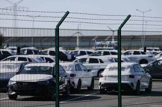 Cars of the Volkswagen Group intended for export to the United States are seen behind a fence at the seaport of Emden, Germany, April 2, 2025. REUTERS/Wolfgang Rattay/File Photo