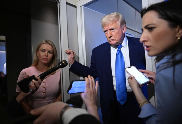 White House Press Secretary Karoline Leavitt listens (left) as President Donald Trump speaks to reporters while in flight on Air Force One, en route to Joint Base Andrews on April 6, 2025.