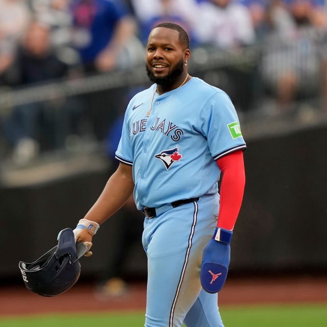 Toronto Blue Jays slugger Vladimir Guerrero Jr. (27) smiles after being tagged at second base by New York Mets shortstop Francisco Lindor (12) during the eighth inning of a baseball game on April 4, 2025, in New York. (AP Photo/Julia Demaree Nikhinson)
