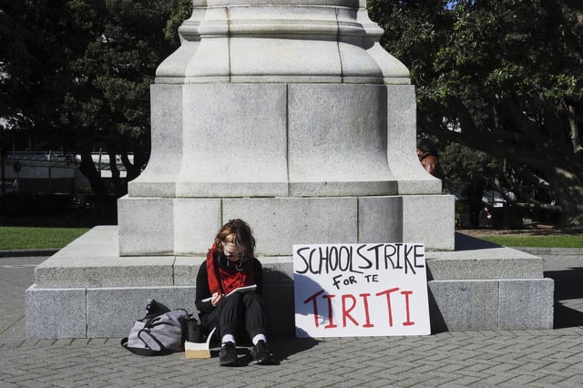 A student opposing the Principles of the Treaty of Waitangi Bill sits outside New Zealand's Parliament in Wellington, New Zealand, Thursday, April 10, 2025.(AP Photo/ Charlotte Graham-McLay)