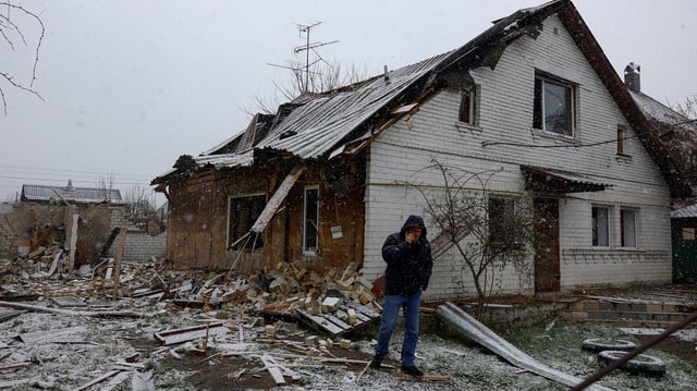 Un homme à côté d’une maison endommagée lors d’une frappe de drone russe à Kyiv en Ukraine, le 10 avril 2025.