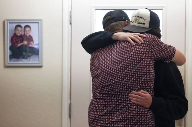 Hunter Metcalf, right, twin brother of Austin Metcalf, is comforted by his uncle at his home in Frisco, Texas.