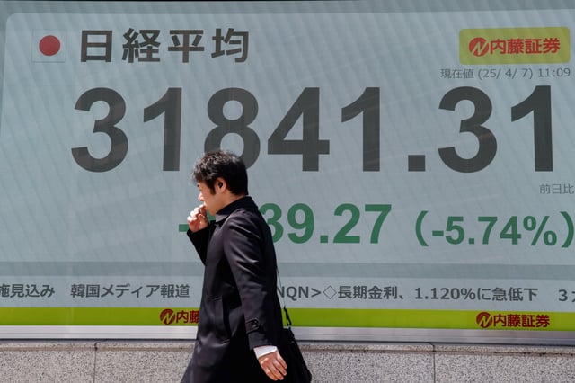 A man walks past a stock quotation board at a brokerage in Tokyo, Japan, April 7, 2025. REUTERS/Androniki Christodoulou/File Photo
