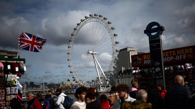 Pedestrians walk along Embankment backdropped by The London Eye, in London, on February 25, 2025.
