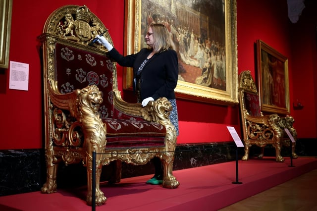 A throne chair and the painting 'The Marriage of George, Duke of York, with Princess Mary of Teck'