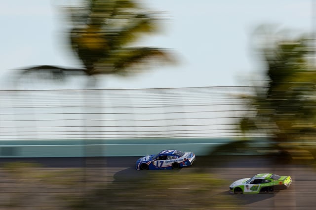 Kyle Larson, driver of the #17 HendrickCars.com Chevrolet, and Sam Mayer, driver of the #41 Audibel Ford, race during the NASCAR Xfinity Series Hard Rock Bet 300 at Homestead-Miami Speedway on March 22, 2025 in Homestead, Florida.