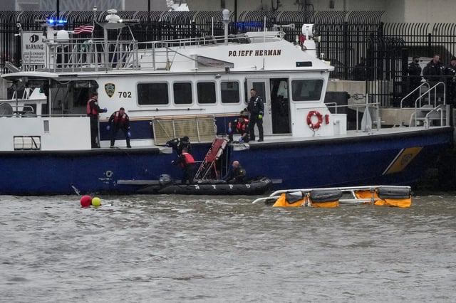 Rescue workers and emergency personnel work at the scene of a helicopter crash on the Hudson River near lower Manhattan in New York, as seen from Newport, New Jersey, on April 10, 2025.