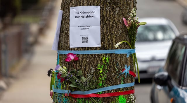 Signage and flowers are placed on a tree next to where ICE agents apprehended Tuft University graduate student Rumeysa Ozturk on March 27, 2025 in Somerville, Massachusetts. Ozturk was arrested for purported activities related to terrorist organizations amid the Trump administration's immigration crackdown. (Scott Eisen/Getty Images)