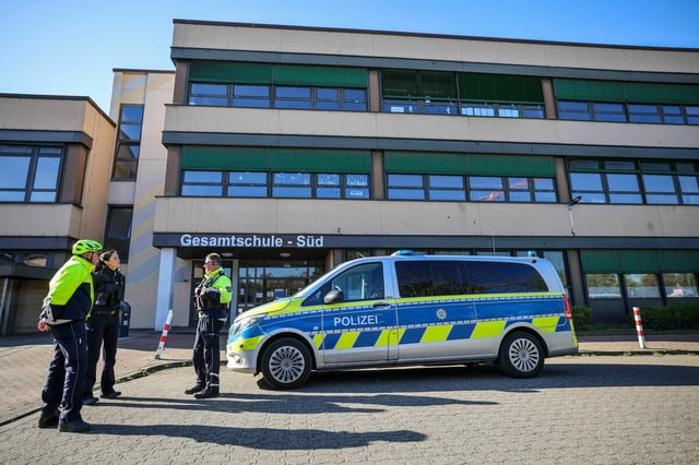 Polizeibeamte stehen vor der Gesamtschule-Süd in Duisburg-Großenbaum