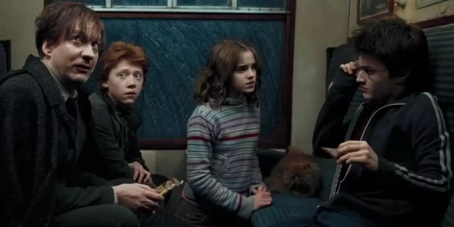 Remus Lupin (David Thewlis), Hermione (Emma Watson), Harry (Daniel Radcliffe), and Ron (Rupert Grint) on the Hogwarts Express in Harry Potter and the Prisoner of Azkaban