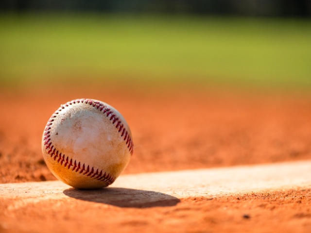 Baseball with dirt on it sitting atop pitchers mound close up