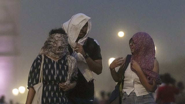 Visitors during a dust storm at the Kartavya Path, near India Gate, in New Delhi on Friday.