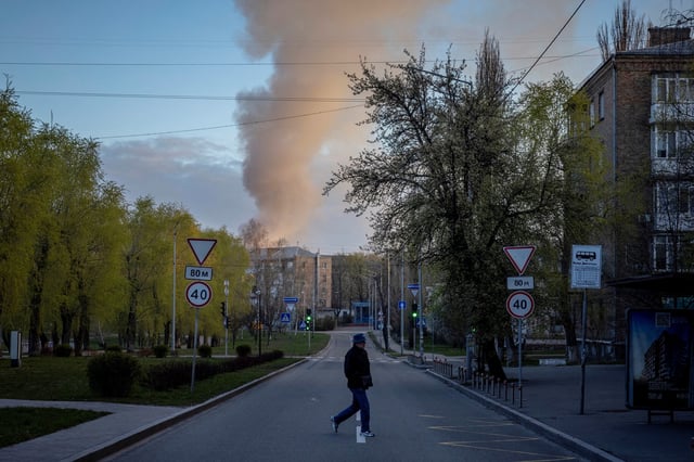 A man crosses a street near the site of a Russian drone attack, amid Russia's attack on Ukraine, in Kyiv, Ukraine April 12, 2025.  REUTERS/Thomas Peter