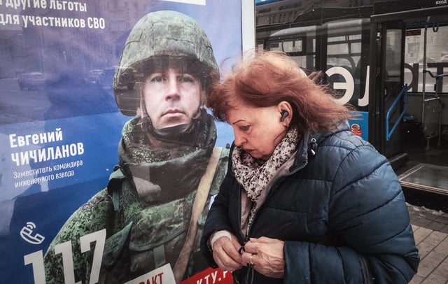 A woman walks past a poster promoting contract army service in western Moscow on April 9, 2025. Ukraine has said Russia recruited soldiers from China to fight.