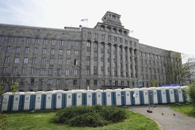 Temporary toilets are installed at street in front of main post office building ahead of a big counter-opposition protest rally planned to stage over the weekend in downtown Belgrade, Serbia, Friday, April 11, 2025. (AP Photo/Darko Vojinovic)