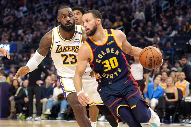 Golden State Warriors guard Stephen Curry (30) dribbles against Los Angeles Lakers forward LeBron James (23) during a game at Chase Center.