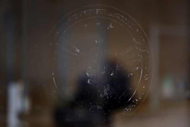 The name and logo for the Consumer Financial Protection Bureau (CPFB) is seen scraped off the door of its building in Washington, D.C., U.S., February 20, 2025. REUTERS/Brian Snyder/File Photo