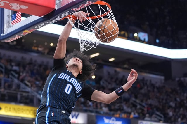 Orlando Magic guard Anthony Black (0) get a basket on a dunk against the Indiana Pacers during the first half of an NBA basketball game in Indianapolis, Friday, April 11, 2025. (AP Photo/Michael Conroy)