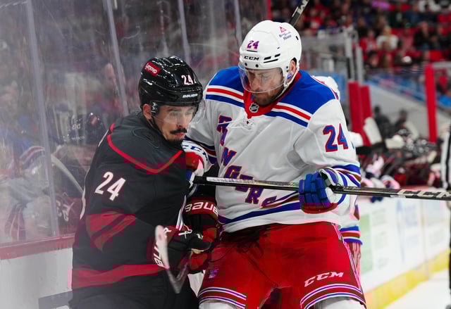 Apr 12, 2025; Raleigh, North Carolina, USA;  New York Rangers defenseman Carson Soucy (24) checks Carolina Hurricanes center Seth Jarvis (24) during the third period at Lenovo Center. Mandatory Credit: James Guillory-Imagn Images