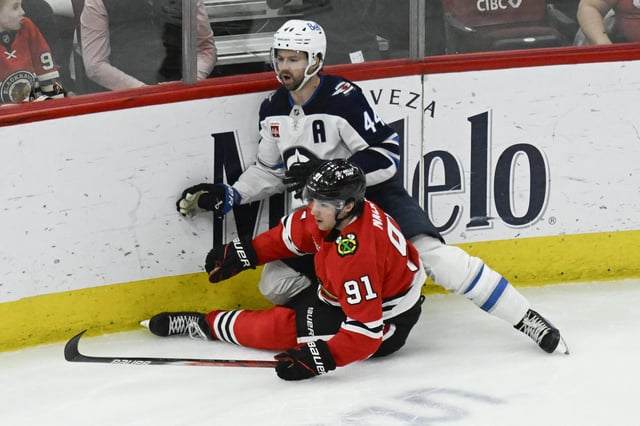 Apr 12, 2025; Chicago, Illinois, USA;  Chicago Blackhawks center Frank Nazar (91) and Winnipeg Jets defenseman Josh Morrissey (44) chase the puck during the third period at United Center. Mandatory Credit: Matt Marton-Imagn Images