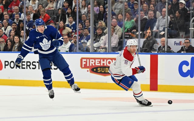 Apr 12, 2025; Toronto, Ontario, CAN;  Toronto Maple Leafs forward Mitch Marner (16) jumps to avoid a bodycheck from Montreal Canadiens defenseman Mike Matheson (8) in the first period at Scotiabank Arena. Mandatory Credit: Dan Hamilton-Imagn Images