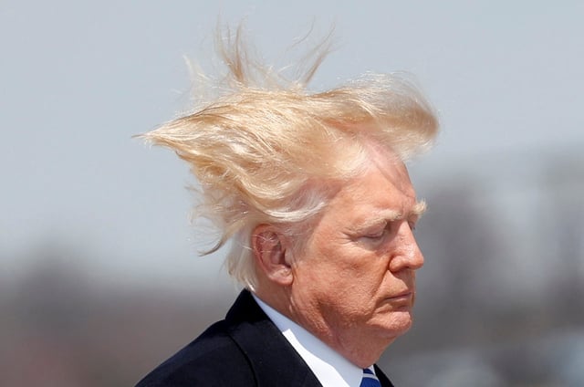 President Donald Trump boards Air Force One on a windy day at Joint Base Andrews, Maryland, before departing for West Virginia in 2018.