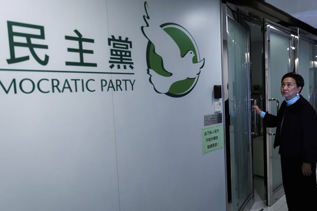 Emily Lau, former chairperson of the Democratic Party, closes the door to the Democratic Party's office in Prince Edward in Hong Kong on April 2, 2025. (AP Photo/May James)