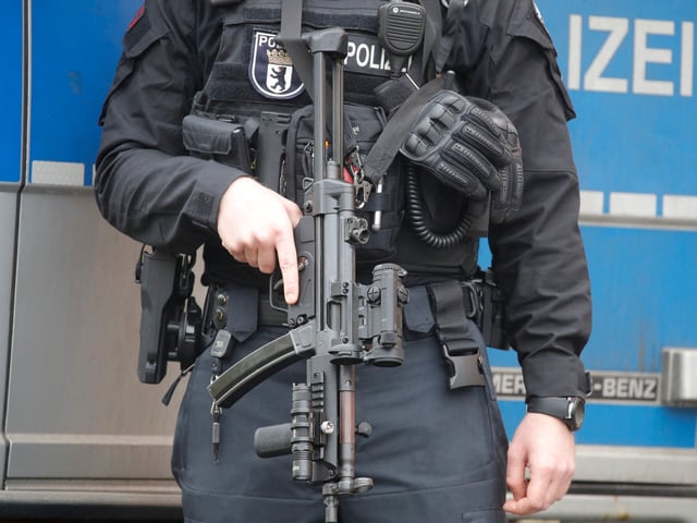 A police officer with a machine gun stands in front of the Al-Irschad Mosque during a raid on April 30, 2020 in Berlin, as dozens of police and special forces stormed mosques and associations linked to Hezbollah in Bremen, Berlin, Dortmund and Muenster in the early hours of the morning. The German government on on April 30, 2020 said it was banning all activities of Lebanon's Iran-backed Hezbollah movement in Germany, calling it a "Shiite terrorist organisation". Although Hezbollah has no official presence in Germany, security forces believe its members use the country as a safe haven and to raise funds, including through criminal activities. (Photo by Odd ANDERSEN / AFP) (Photo by ODD ANDERSEN/AFP via Getty Images)