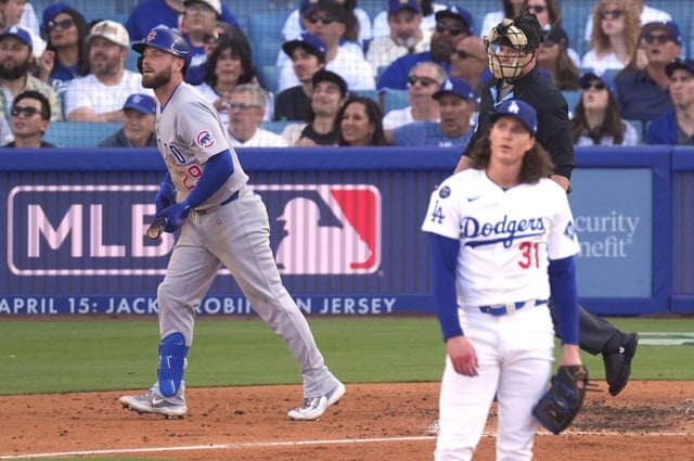 Chicago Cubs’ Michael Busch, left, heads to first after hitting a solo home run as Los Angeles Dodgers starting pitcher Tyler Glasnow, watches during the sixth inning of a baseball game Sunday, April 13, 2025, in Los Angeles. (AP Photo/Mark J. Terrill)