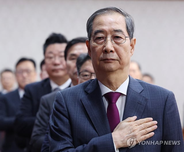 Acting President Han Duck-soo salutes the national flag during a Cabinet meeting at the government complex in Seoul on April 14, 2025. (Pool photo) (Yonhap)