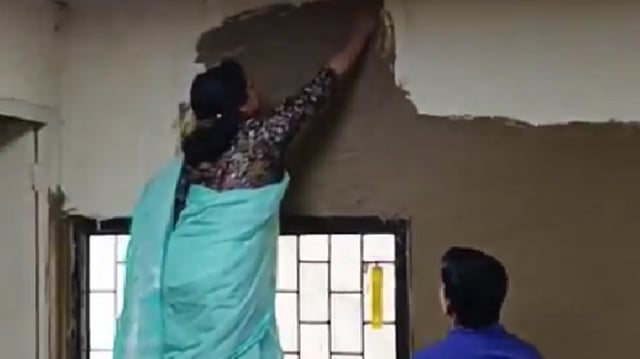 Delhi University's Laxmibai College principal seen applying cow dung on classroom walls in a bid to tackle heat. (Screengrab)