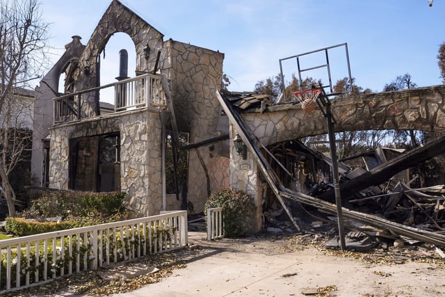 FILE - A basketball is stuck in the net outside of a residence destroyed by the Palisades Fire in the Pacific Palisades neighborhood of Los Angeles, Friday, Jan. 24, 2025. (AP Photo/Damian Dovarganes, File)